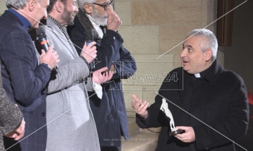 Don Enzo Gabrieli con in mano una riproduzione del Cristo alla Colonna