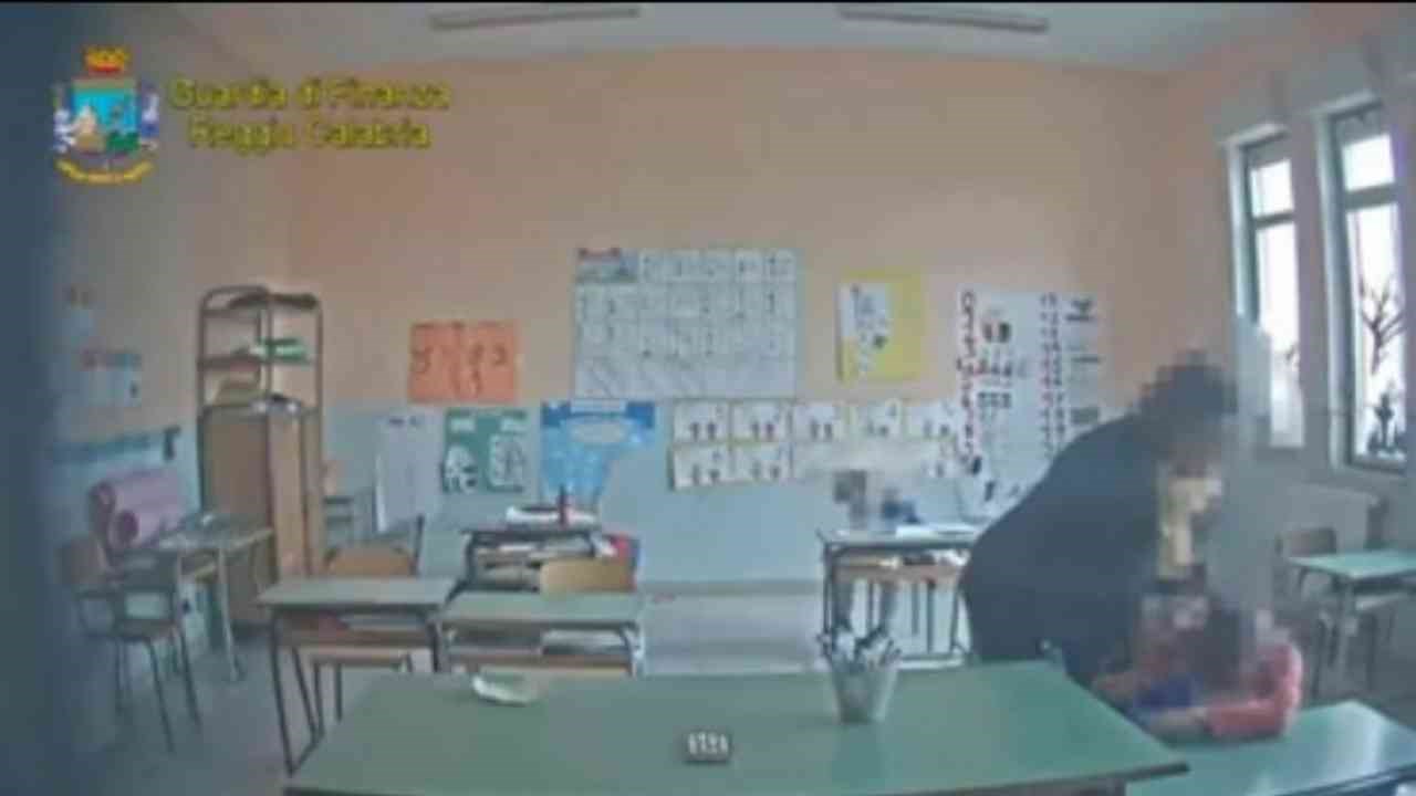 La maestra e un alunno ripresi dalle telecamere installate nella scuola