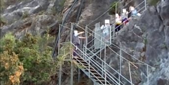 Alcuni turisti sulla scala che dà accesso alla spiaggia della Grotta del Prete