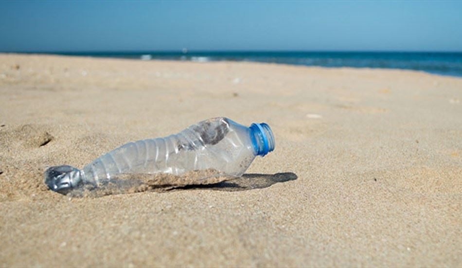 Una bottiglia abbandonata in spiaggia